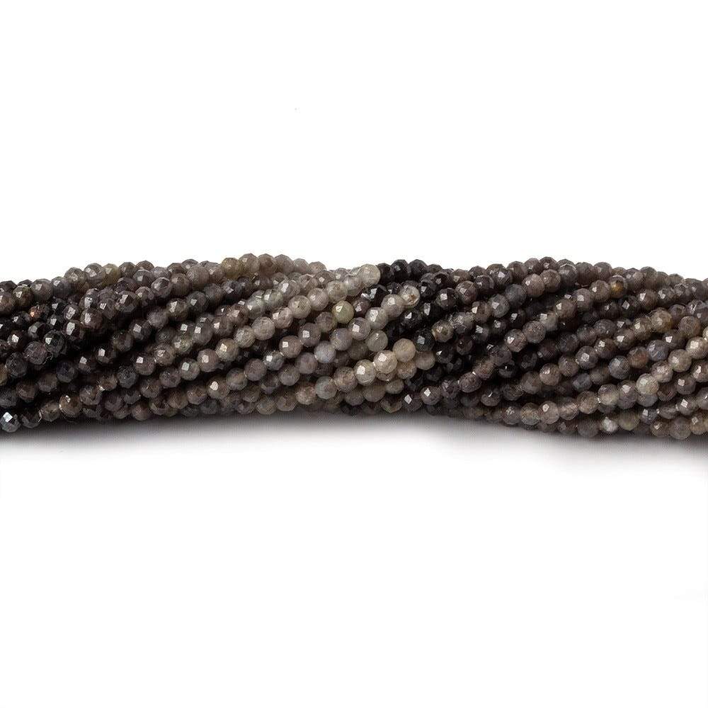 Coiled strands of multi-tonal grey and brown sapphire micro-faceted round beads on a white background.