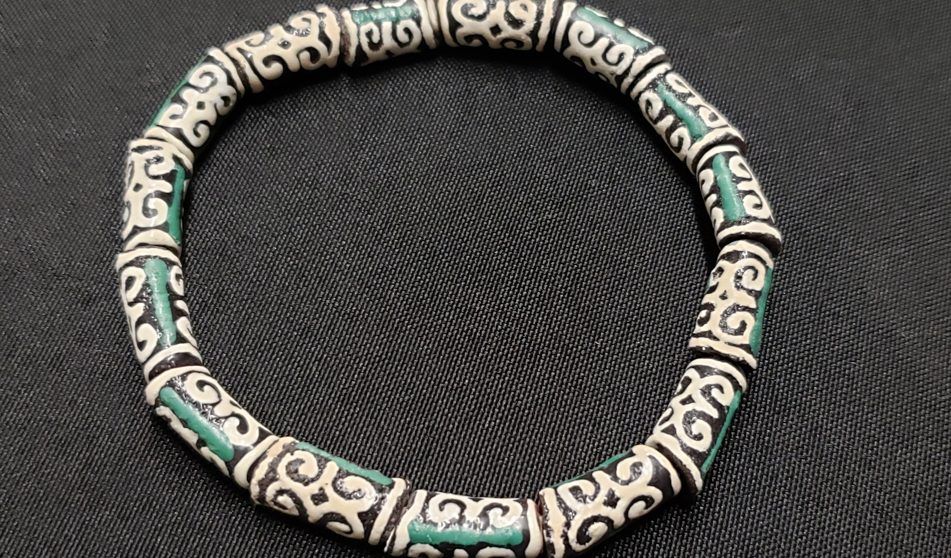 small adinkra glass beads ram horn humility strength ghana krobo green cream strand top view