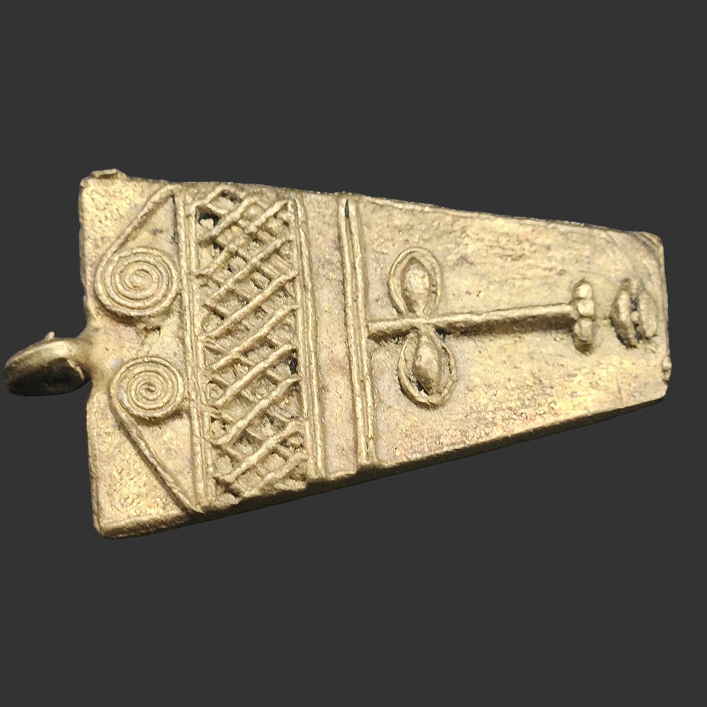african brass ancient tribal mask pendant close up texture