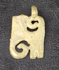 Small brass Kwatakye Atiko pendant with two diagonal spiral openings, a textured rectangular center, and a top hanging loop on dark fabric