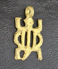 Brass openwork pendant with an oval center, projecting corners, and a top hanging loop on a dark textured background.
