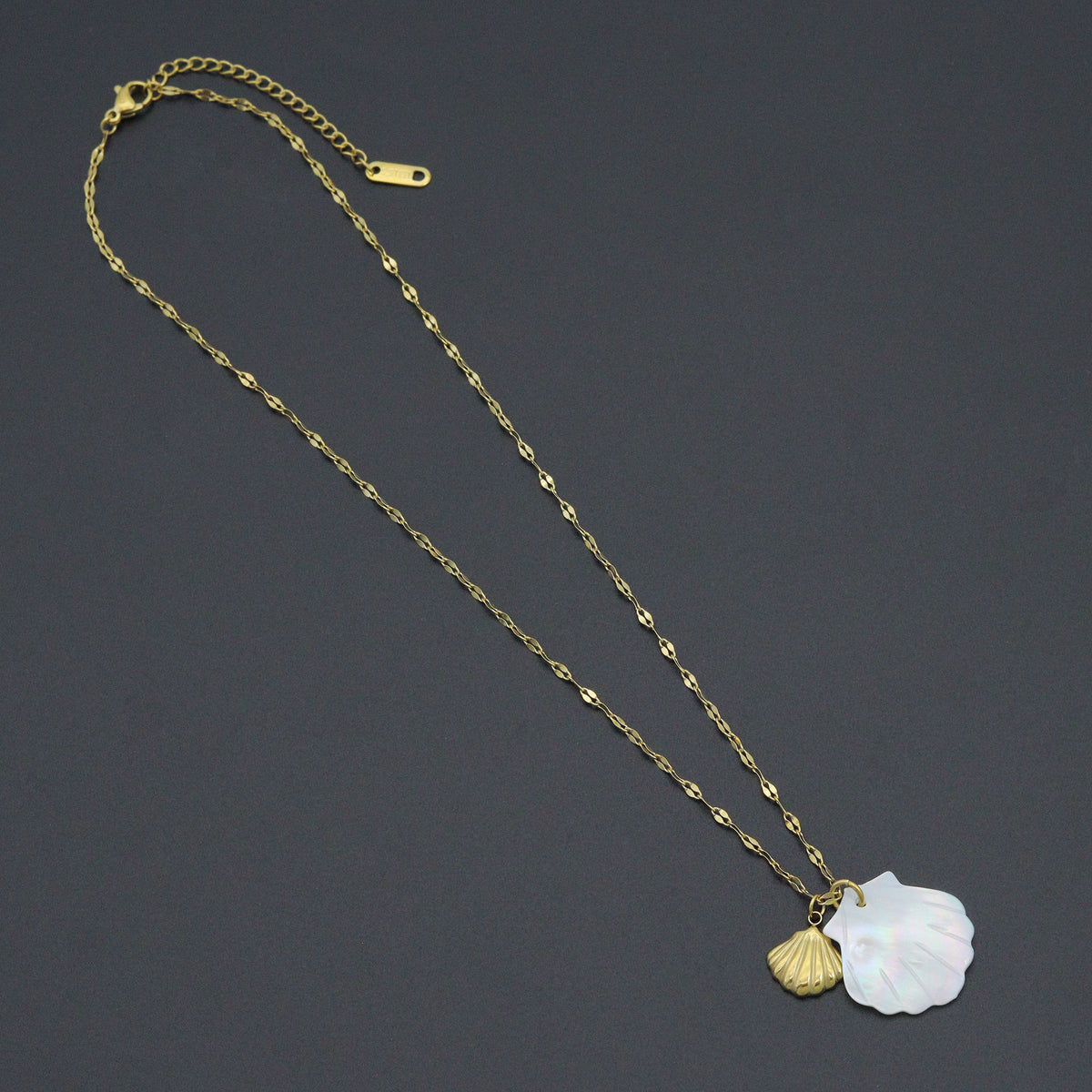 Fine gold-tone necklace with a white iridescent shell pendant and a smaller gold-tone shell charm