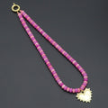 Pink and magenta rondelle bead necklace with a gold-tone heart pendant and round clasp