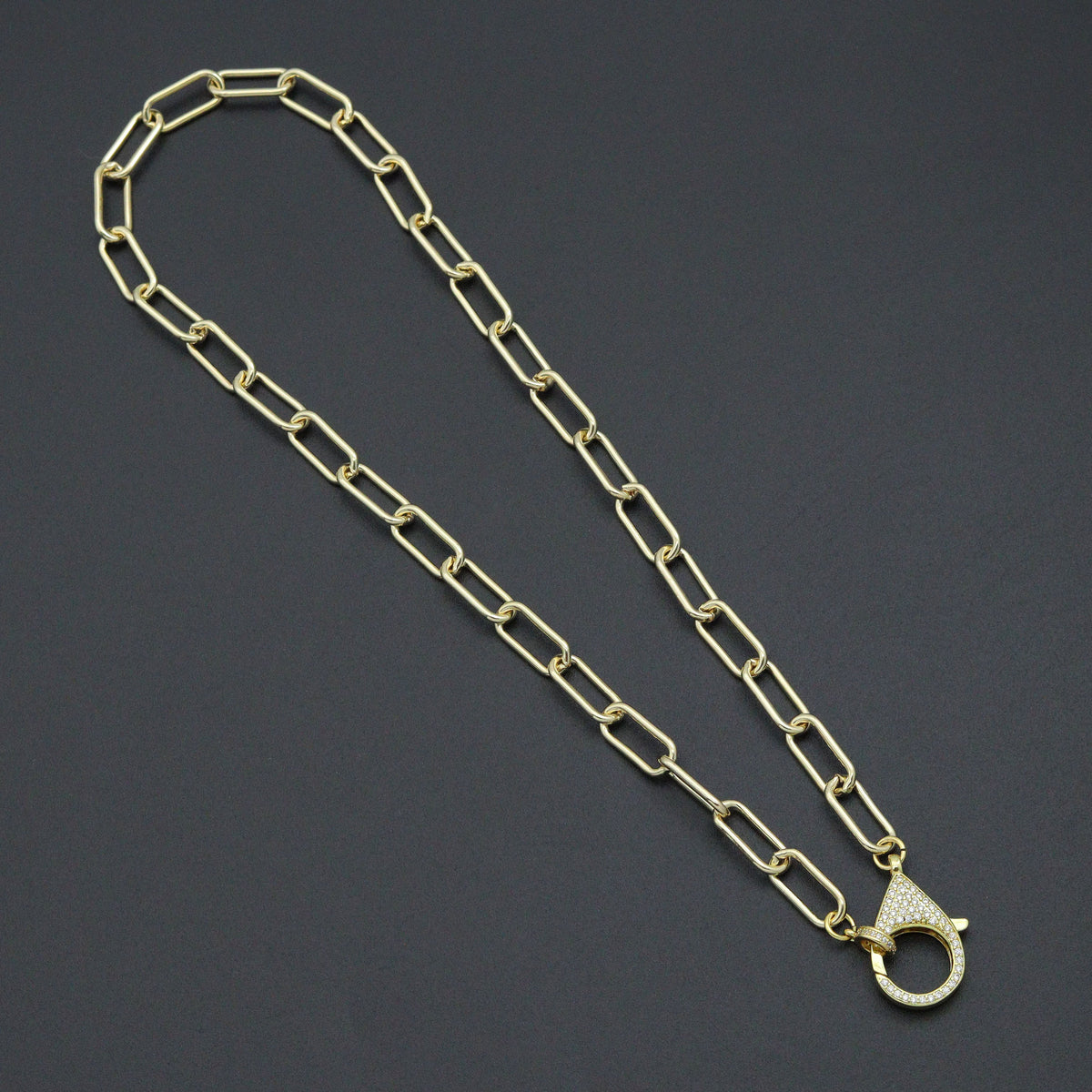 Gold-tone paperclip-link necklace with a large clear-stone lobster clasp