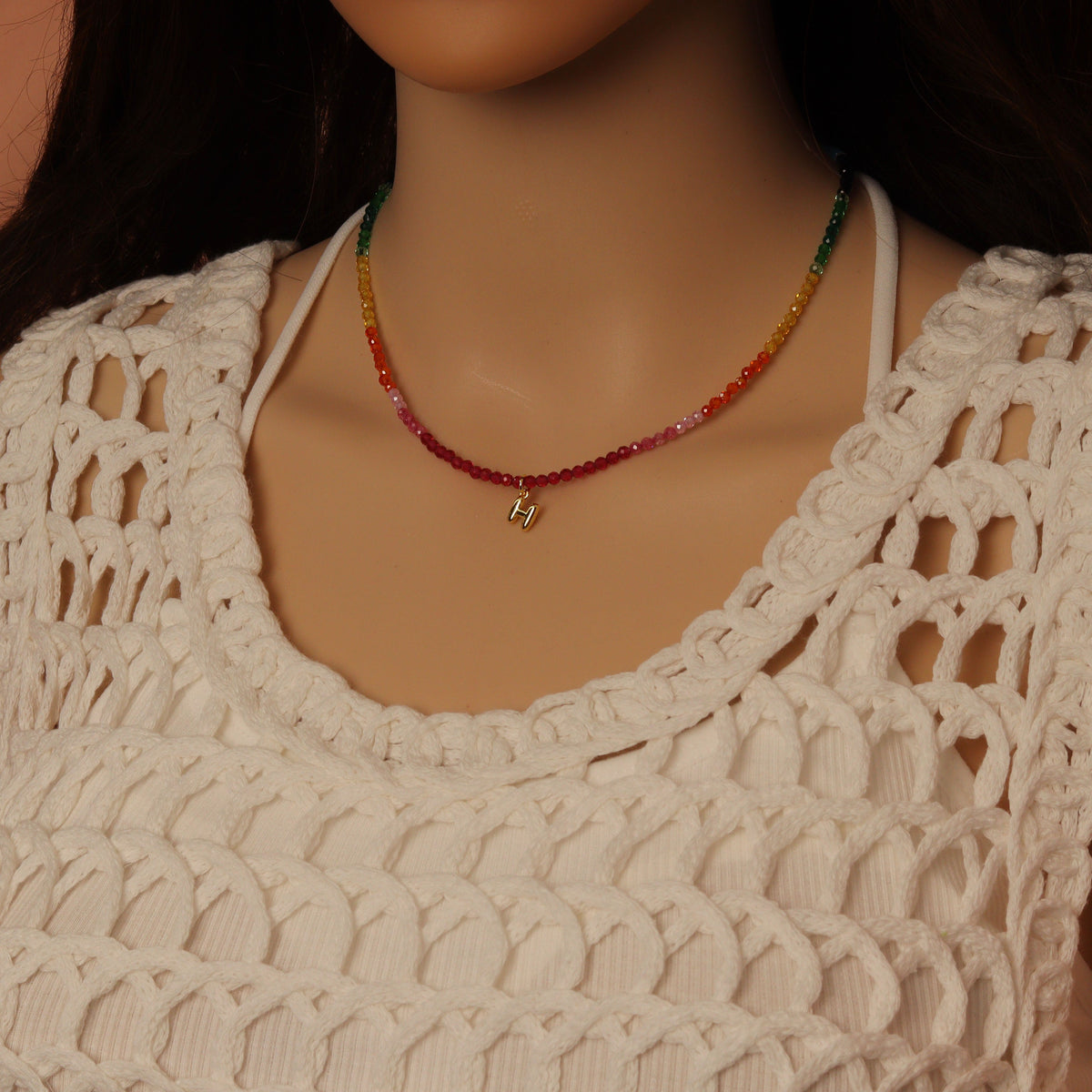 Rainbow bead necklace worn with a gold-tone letter M charm
