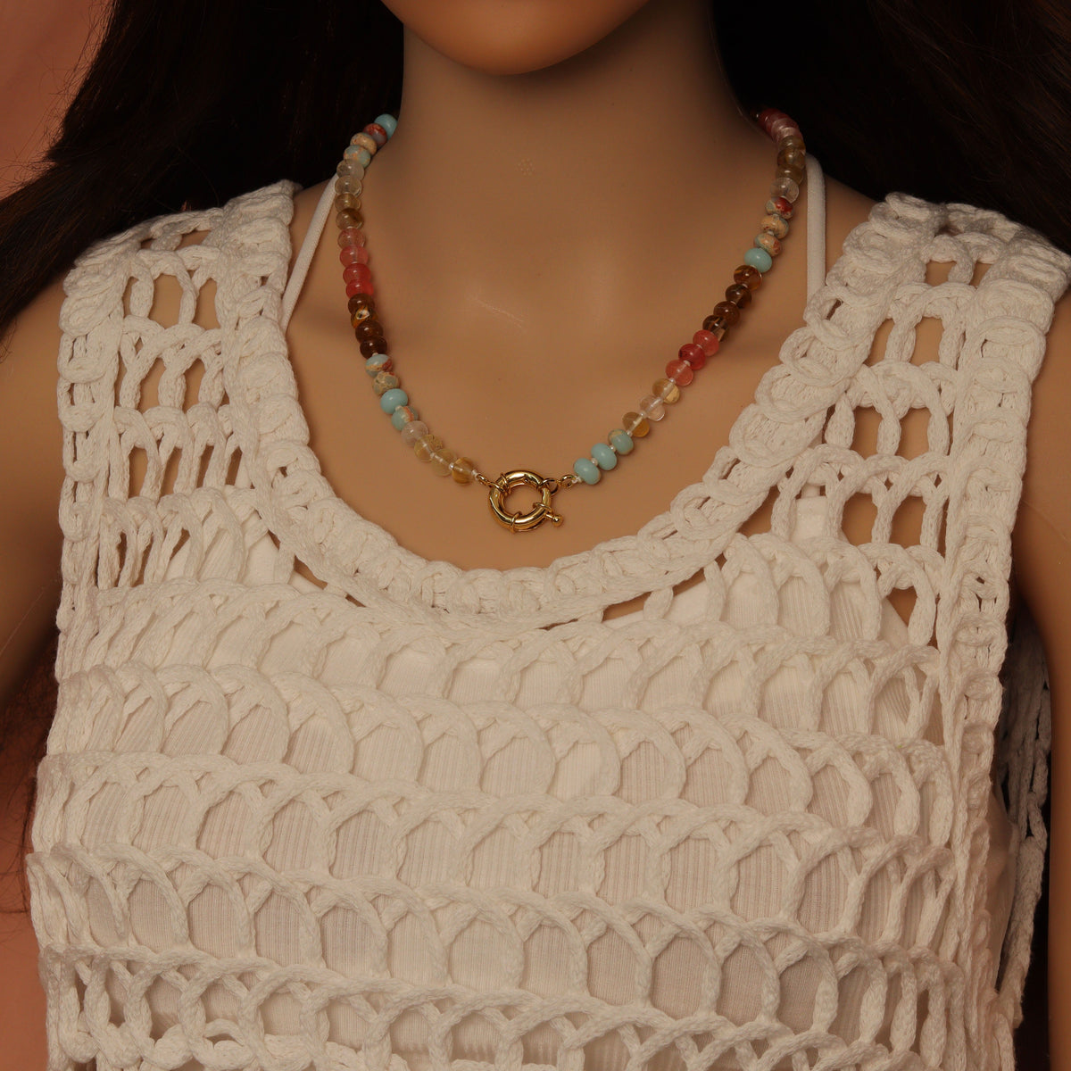 Multicolored rondelle necklace worn with its gold-tone round clasp at the front