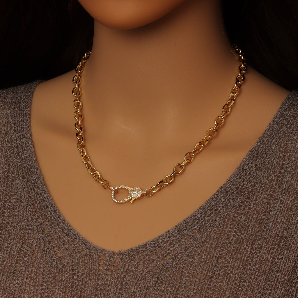 Gold-tone rolo chain necklace worn with its sparkling clasp at the front