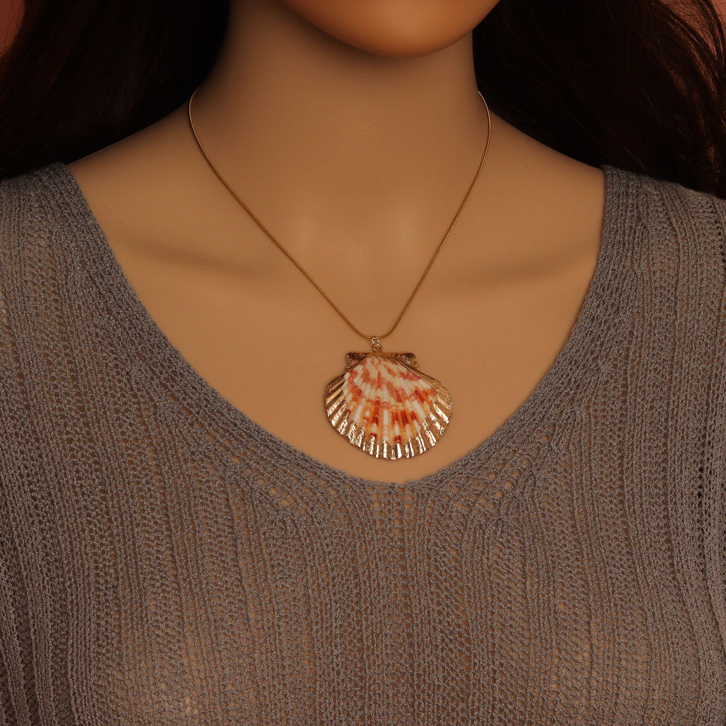 Scallop shell pendant necklace worn with the pendant centered below the collarbone