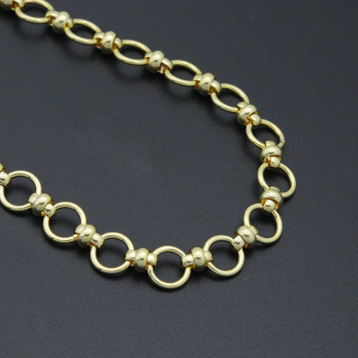 Close-up of gold-tone circular links joined by small rounded connectors