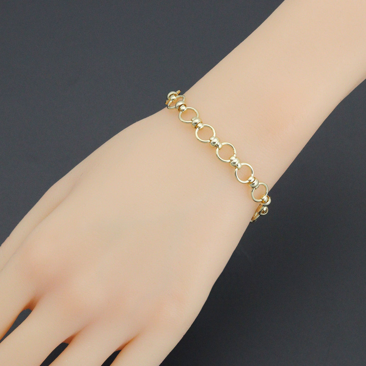Gold-tone round-link bracelet worn on a wrist