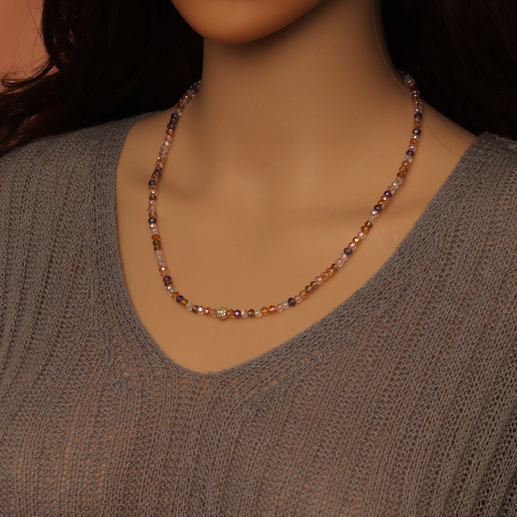 Multicolored crystal bead necklace worn with its sparkling gold-tone accent bead at the front