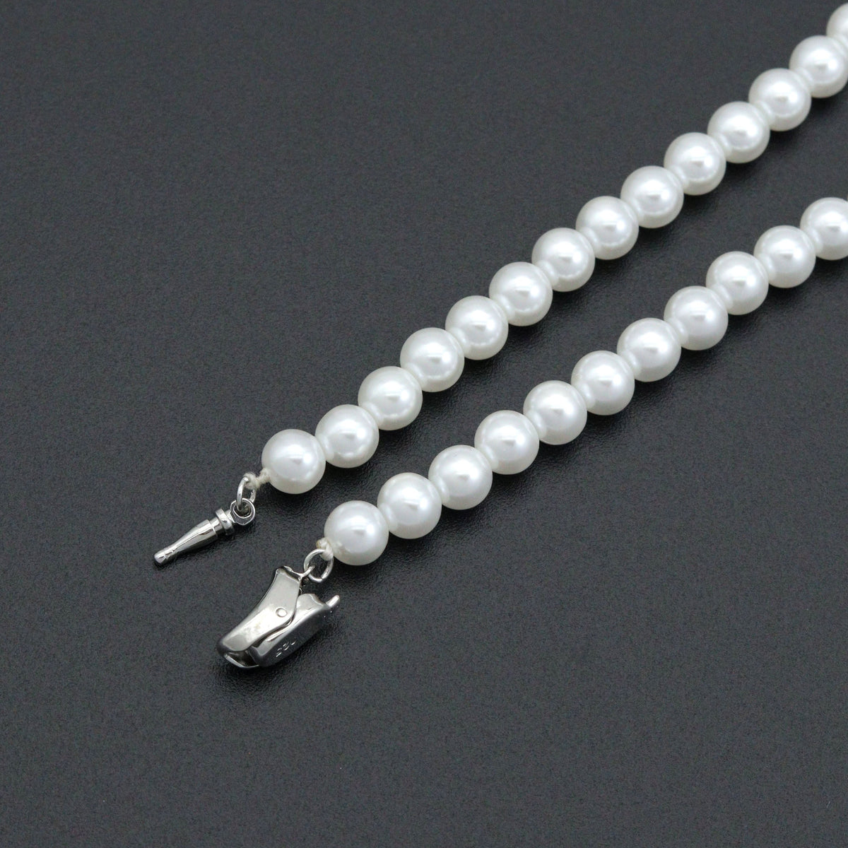 Close-up of the pearl bead necklace open silver-tone clasp and white beads
