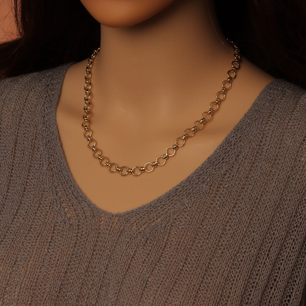 Gold-tone round-link necklace worn without a pendant