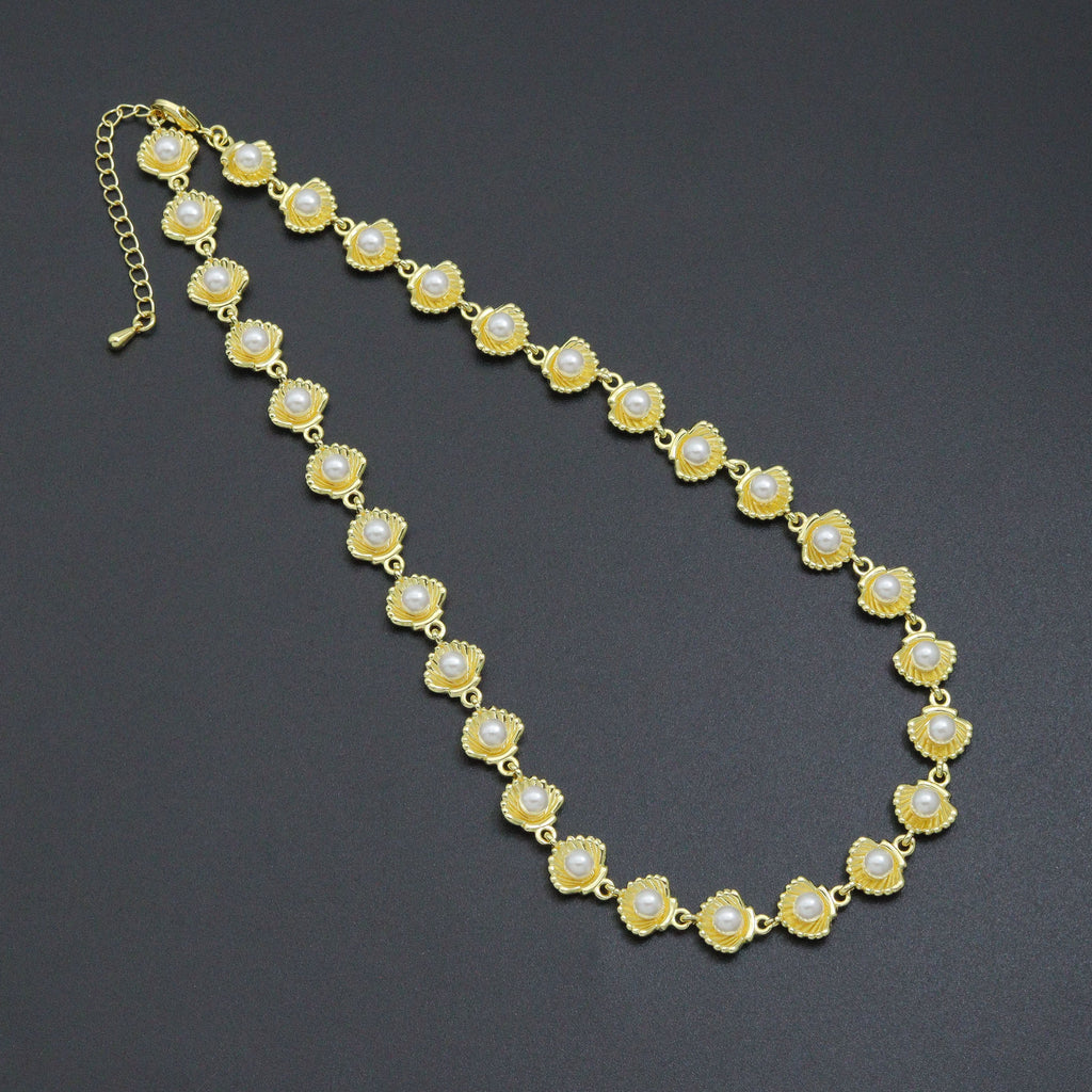 Gold-tone necklace with white pearl-like beads centered on linked shell-shaped settings