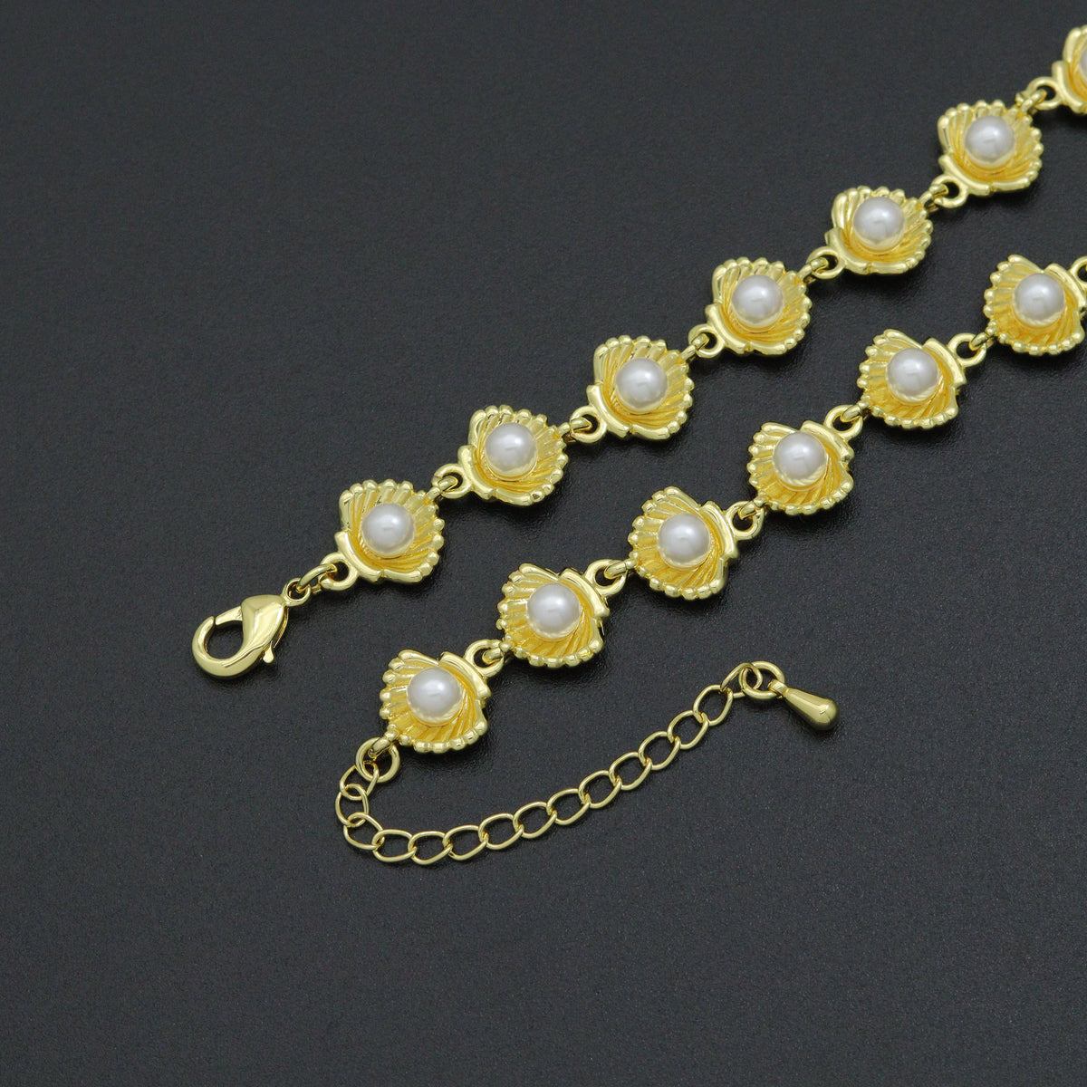 Pearl and shell-link necklace showing its gold-tone lobster clasp and extender