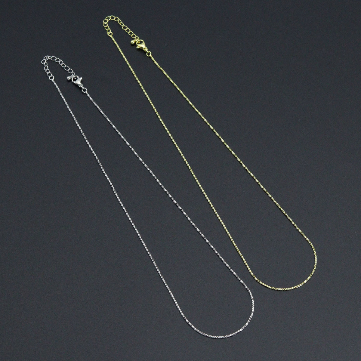 Gold-tone and silver-tone thin box chain necklaces with lobster clasps and extender chains