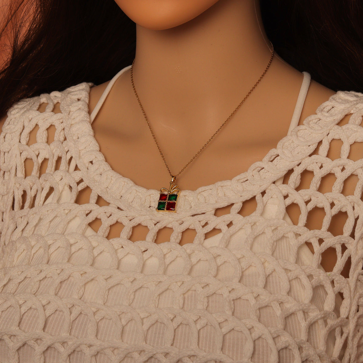 Red and green gift-box pendant necklace worn with a white top