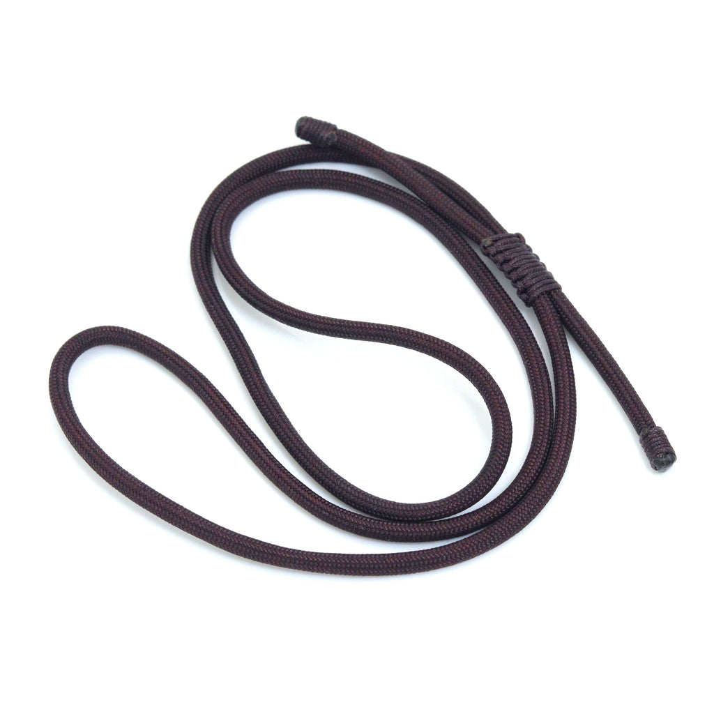 Dark cord necklace loosely coiled with its sliding knot visible