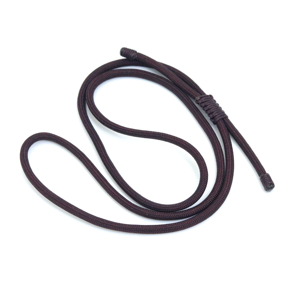 Dark cord necklace loosely coiled with its sliding knot visible