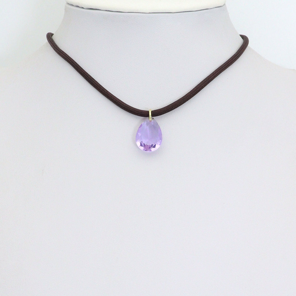 Dark cord necklace displaying a lavender teardrop pendant on a white bust