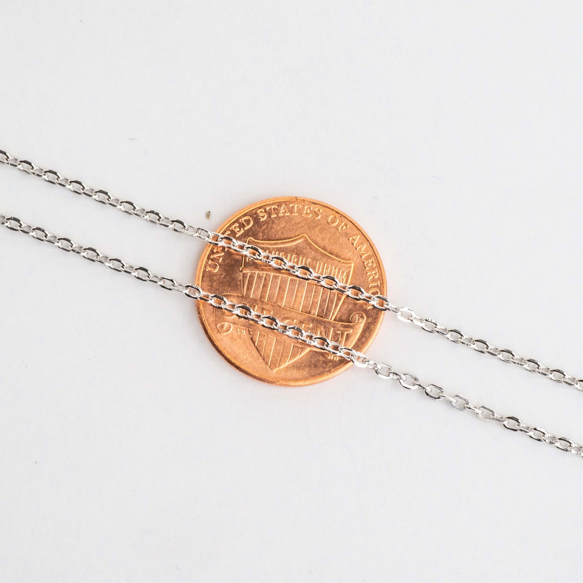 1.5mm cable chain links shown across a penny for scale