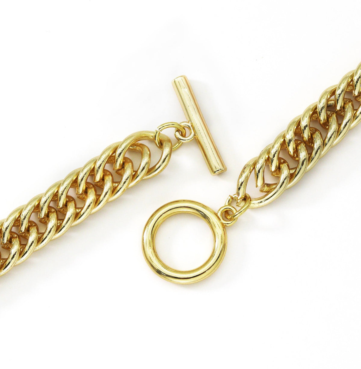 Close-up of an open gold-tone toggle clasp and chunky curb links